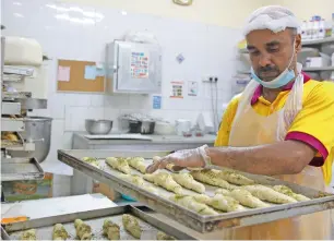  ?? Photos by Juidin Bernarrd ?? A worker arranges variety of croissants at Habib Bakery in Dubai. —