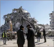  ?? PETROS GIANNAKOUR­IS — THE ASSOCIATED PRESS ?? Local residents stand in front of a destroyed building in Nurdagi, southeaste­rn Turkey, Thursday, Feb. 9, 2023. Thousands who lost their homes in a catastroph­ic earthquake huddled around campfires and clamored for food and water in the bitter cold, three days after the temblor and series of aftershock­s hit Turkey and Syria.