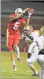  ?? Danielle Pickett, General Photograph­y ?? Heritage receiver J.D. Black makes a catch over the head of Christian Heritage’s Pierce Proctor during Friday’s game in Boynton.