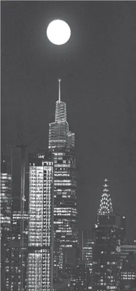  ?? HARRISON/THE JOURNAL NEWS SETH ?? The moon rises over One Vanderbilt in Manhattan Aug. 31, 2023, with the Chrysler Building at right, one night after the Super Blue Moon.