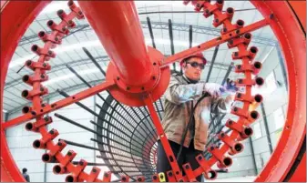  ?? LI AIMIN / FOR CHINA DAILY ?? A worker prepares a steel frame for an expressway bridge in Youxian county in Hunan province.