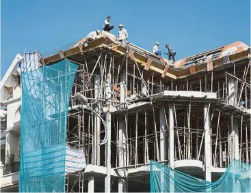  ??  ?? Vietnam real estate: Workers labour at a residentia­l constructi­on site in Ho Chi Minh City, Vietnam. Vinhomes develops serviced apartments and villas in the country’s biggest cities. — Bloomberg