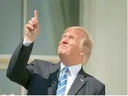  ?? — AP ?? Donald Trump points skyward without wearing protective during the total solar eclipse.