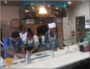  ?? GARY PULEO - MEDIANEWS GROUP ?? Making a pizza at the counter are, from left, Rachel Foley, Ryan Welburn and Keith Richardson.