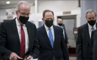  ?? J. Scott Applewhite/Associated Press ?? Sen. Jerry Moran, R-Kan., left, Sen. Pat Toomey, R-Pa., and others head to the chamber as the Senate holds a voting marathon on the Democrats’ $1.9 trillion COVID-19 relief bill that’s expected to end with the Senate’s approval of the measure.