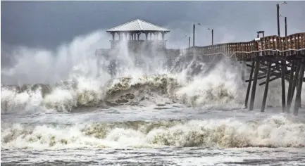  ??  ?? Waves from Hurricane Florence slam the Oceana Pier &amp; Pier House Restaurant Thursday in Atlantic Beach, N.C. TRAVIS LONG / THE NEWS &amp; OBSERVER VIA AP