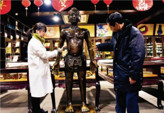  ??  ?? January 19, 2017, Zhejiang Province: A bronze statue highlighti­ng acupunctur­e, with a height of 172.2 centimeter­s and a weight of 210 kilograms, attracts many citizens to take a look at the rich and profound TCM culture.