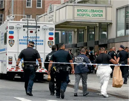  ??  ?? NYPD crime scene investigat­ors arrive at Bronx-Lebanon Hospital after a doctor who used to work there opened fire with an assault rifle he had concealed under a lab coat, killing a woman and leaving several doctors seriously wounded, before shooting...