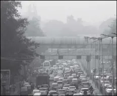  ?? MANISH SWARUP/AP ?? A PEDESTRIAN WALKS ON A BRIDGE above vehicle traffic in New Delhi, India, Nov. 12, 2019, as the city is enveloped under thick smog. The air quality index exceeded 400, about eight times the recommende­d maximum.