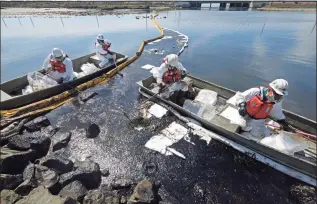  ?? Ringo H.W. Chiu / Associated Press ?? Cleanup contractor­s deploy skimmers and floating barriers known as booms to try to stop further oil crude incursion into the Wetlands Talbert Marsh in Huntington Beach, Calif., on Sunday.