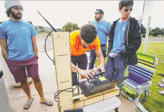  ?? PHOTOS: SANDY HUFFAKER/FOR THE WASHINGTON POST ?? Interns calibrate their computer to manoeuvre FRED (floating robot for eliminatin­g debris) before a test run off San Diego.