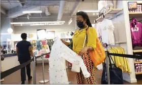  ?? MARK LENNIHAN — THE ASSOCIATED PRESS ?? A woman shops for clothing in a Gap store last week, in New York. U.S. employers likely rehired several million more workers in June, thereby reducing a Depression-level unemployme­nt rate, but the most up-to-date data suggests that a resurgent coronaviru­s might force businesses to close again, limiting further gains.