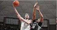  ?? Jessica Hill/Associated Press ?? UConn’s Alex Karaban (11) shoots around Providence’s Bryce Hopkins on Feb. 22 in Storrs.