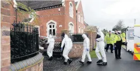  ??  ?? > Forensic teams at the address after three members of a family, including a young boy, were stabbed in their home
