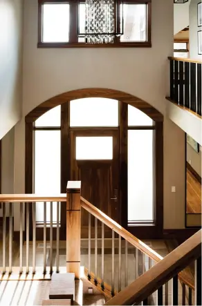  ??  ?? A custom, curved walnut front entry exhibits frosted transom and side lite details.