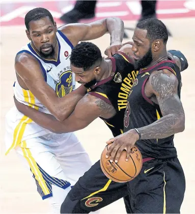  ?? THEARON W. HENDERSON/GETTY IMAGES ?? Cleveland’s Tristan Thompson helps LeBron James fend off Golden State’s Kevin Durant in Thursday night’s opener of the NBA final in Oakland. The game ended after the Star’s deadline. Full report at thestar.com.