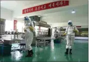  ?? CHA SONG HO / AP, FILE ?? Health officials of the Pyongyang Sports Goods Factory disinfect the floor of a work place in Pyongyang, North Korea on June 14. The red banner says “Economy means increased production and patriotism.”