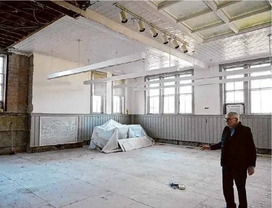  ?? Photos by Will Waldron/times Union ?? Paul Hicok, director at Troy Public Library, looks over repairs being made to the city’s Lansingbur­gh Library branch on Third Avenue and 114th St. in Troy on Thursday. Troy Public Library is seeking money to completely repair water damage after an insurance claim was denied.