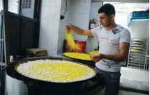  ?? (Raneen Sawafta /Reuters) ?? A WORKER prepares kanafeh in a shop in Nablus last week.