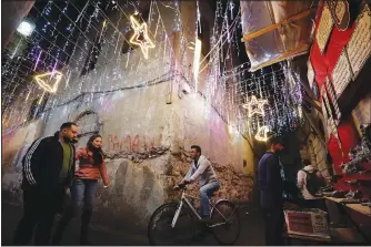  ?? (AP/Omar Sanadiki) ?? People walk Dec. 14 in the Old City of Damascus, Syria, which is decorated for the upcoming Christmas holidays.