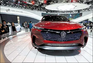  ?? AP file photo ?? Visitors look at a Buick Enspire concept car on display at Auto China 2018 in Beijing in April. China said Tuesday it will reduce its auto import tariffs from 25 percent to 15 percent effective July 1.