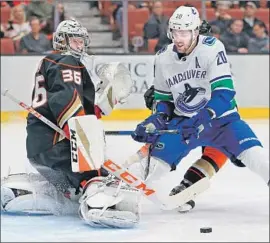  ?? Sean M. Haffey Getty Images ?? DUCKS GOALIE JOHN GIBSON defends against Brandon Sutter of the Vancouver Canucks during the second period. Gibson stopped 32 shots.