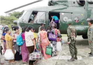  ??  ?? MAUNGDAW, Myanmar: Myanmar Air Force personnel evacuate civil servants with a military helicopter from in Rakhine State on Thursday. — AFP