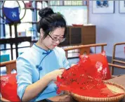  ?? PHOTOS PROVIDED TO CHINA DAILY Above: ?? Top: Dishes with correspond­ing paper-cut patterns in Pucheng, Fujian province. Wang Xu is making paper-cuts in her workshop.