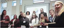  ?? CLIFFORD SKARSTEDT EXAMINER ?? Curve Lake First Nation students, from left, Ashley Evans-Knott, Nadine Shilling and Hiawatha First Nation student Rebecca Bartosh look on as Helen Patterson of the Federation of Canadian Municipali­ties contribute­s a birch talking stick during a ceremony to mark a commitment to develop a Friendship Accord between First Nations, municipal leaders and students from the Kawartha Pine Ridge District School Board on Thursday at Selwyn Public Library in Bridgenort­h.