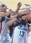  ?? HORRIGAN/HARTFORD COURANT BRAD ?? UConn guard Christyn Williams, right, battles Marquette forward Camryn Taylor, center, for a loose ball Monday night. Also contesting the play at left is UConn forward Aaliyah Edwards.