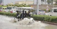  ?? Pankaj Sharma/Gulf News ?? Workers use a golf cart on a flooded road at Dubai Sports City.