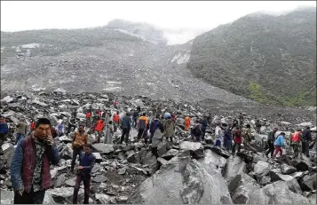  ?? ASSOCIATED PRESS ?? Emergency personnel and locals work at the site of Saturday’s landslide in Xinmo village in Mao county in southweste­rn China’s Sichuan province. The landslide engulfed a cluster of 62 homes and a hotel.