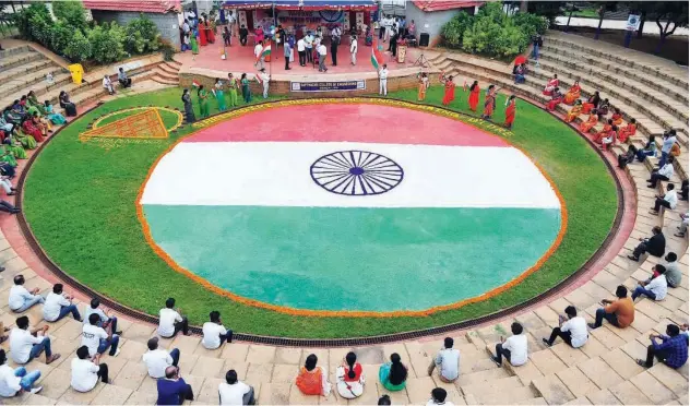  ?? Agence France-presse ?? ↑
Students and faculty members of an engineerin­g college sit around a large Indian flag drawn in the amphitheat­re in Bengaluru, Karnataka, on Friday.