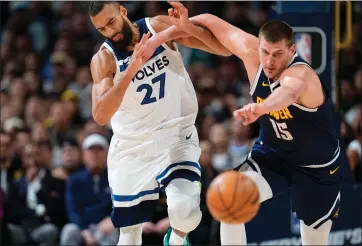  ?? DAVID ZALUBOWSKI — THE ASSOCIATED PRESS ?? Denver Nuggets center Nikola Jokic, right, pushes Minnesota Timberwolv­es center Rudy Gobert while they pursue the ball during the second half Wednesday in Denver.