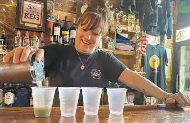  ?? COURTESY OF JENN AIREY ?? Cat’s Eye Pub bartender Jenn Airey pours a drink for customers at the Fells Point bar.