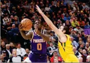  ?? ASSOCIATED PRESS ?? PHOENIX SUNS’ Jawun Evans (0) attempts a layup as Utah Jazz’s Ricky Rubio (right) defends in the first half of a game on Wednesday in Salt Lake City.