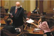  ?? Rich Pedroncell­i / Associated Press ?? Senate budget committee members Mike McGuire (left), Jim Beal and Nancy Skinner confer Friday.