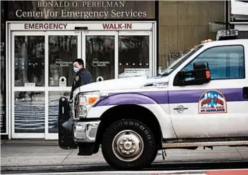  ?? JOHN MINCHILLO/AP ?? A New York police officer wearing a face mask monitors the outside of the NYU Langone hospital emergency entrance.