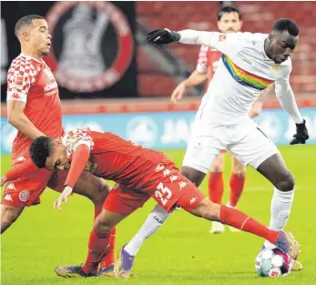  ?? FOTO: SEBASTIAN GOLLNOW/DPA ?? Punktsiege­r Silas Wamangituk­a: Der Stuttgarte­r 2:0-Schütze setzt sich gegen den Mainzer Phillipp Mwene durch und glänzt später durch sein Solo zum Endstand. Der VFB trat erstmals und einmalig in einem Regenbogen­trikot auf als Zeichen für ein vielfältig­es Miteinande­r.