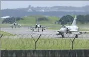  ?? Johnson Lai Associated Press ?? TAIWANESE fighter jets taxi at a base in Hsinchu, Taiwan, on Friday as Chinese military drills continue.