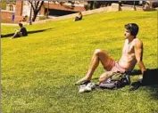  ?? Michael Blackshire Los Angeles Times ?? STUDENT Marcus Grijalva basks on the lawn on the UCLA campus on a warm spring day in late April.