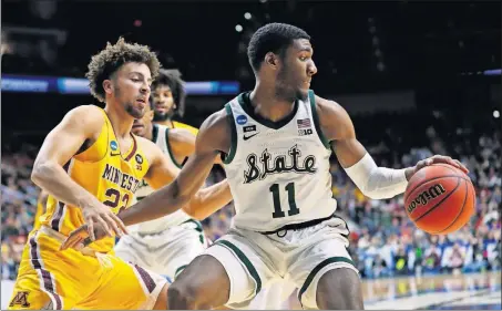  ?? [CHARLIE NEIBERGALL/ THE ASSOCIATED PRESS] ?? Michigan State forward Aaron Henry (11) drives around Minnesota guard Gabe Kalscheur, left, in the Spartans’ win over Minnesota on Saturday.