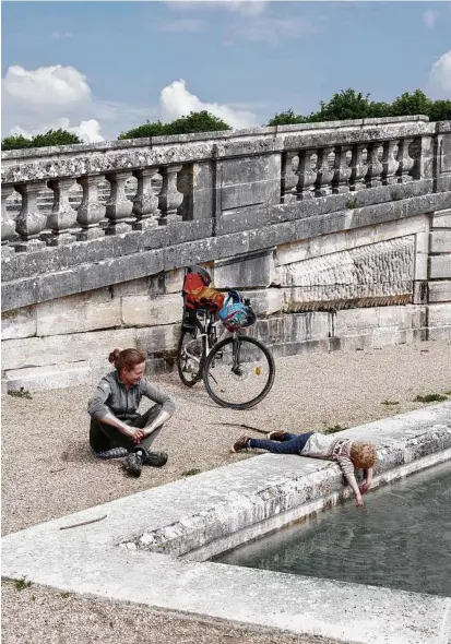  ?? Photos by Elliott Verdier / New York Times ?? A mother and son relax near the grand canal of the Versailles gardens.