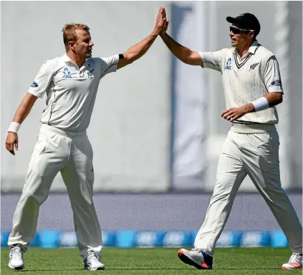  ?? PHOTOS: PHOTOSPORT ?? New Zealand pace bowlers Neil Wagner, left, and Tim Southee celebrate another wicket as the Black Caps march to an eight-wicket victory over Pakistan in Christchur­ch yesterday.