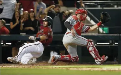  ?? ROSS D. FRANKLIN — THE ASSOCIATED PRESS ?? The Diamondbac­ks’ Paul Goldschmid­t, a late throw in the 11th inning Sunday. left, scores the winning run as Phillies catcher Andrew Knapp waits for