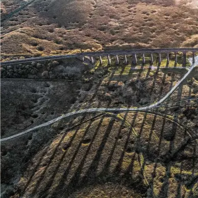  ?? LES LIDDLE. ?? An aerial view of the viaduct as the sun sets over Morecambe Bay shows the remains of Batty Moss constructi­on site. The indentatio­ns are sink holes, while the trackways of former industrial railways and tramways can be clearly seen.