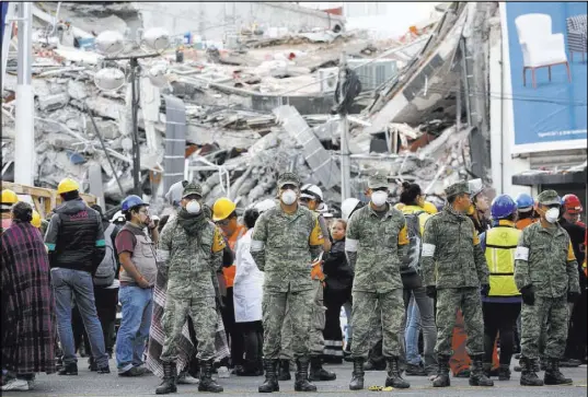  ?? Rebecca Blackwell The Associated Press ?? Rescue workers and volunteers stand in the middle of the street after an earthquake alarm sounded and a small tremor was felt Saturday in Mexico City.