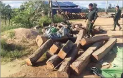  ?? GRK ?? Officials inspect timber seized in a raid on a timber warehouse in Kampong Speu province earlier this week.