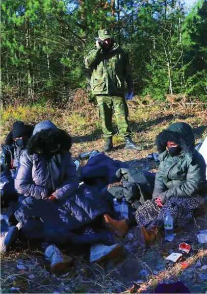  ?? REUTERS ?? Un grupo de migrantes de Somalia en Siemianowk­a, Polonia, junto a la frontera con Bielorrusi­a