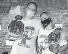  ?? AP ?? Joey Chestnut and Miki Sudo pose for the cameras after winning their respective divisions at Nathan’s Famous July Fourth hot dogeating contest on Saturday in New York.